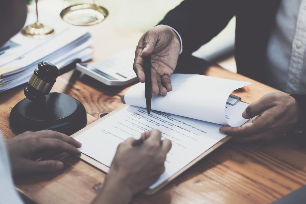 business-woman-lawyers-discussing-contract-papers-with-brass-scale-wooden-desk-office-law-legal-services-advice-justice-concept